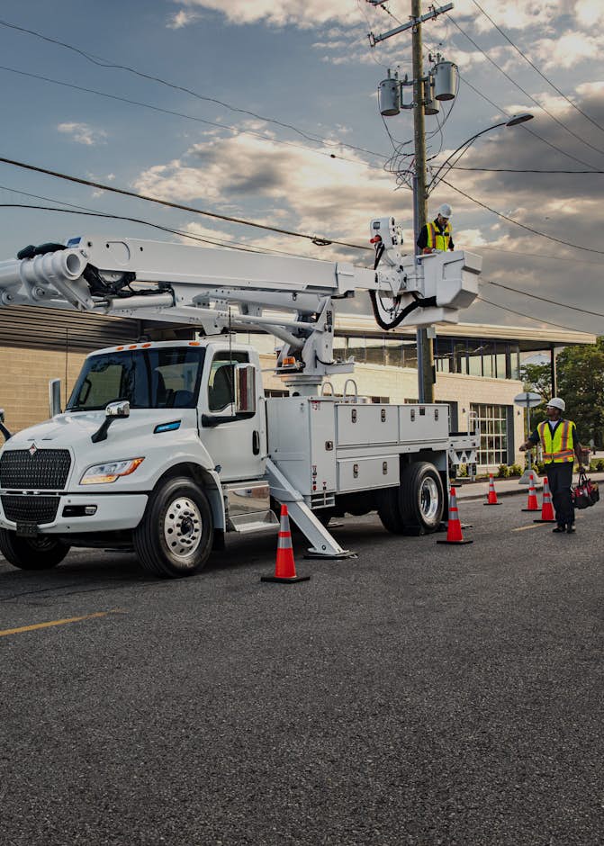 A white truck with a crane on top of it
