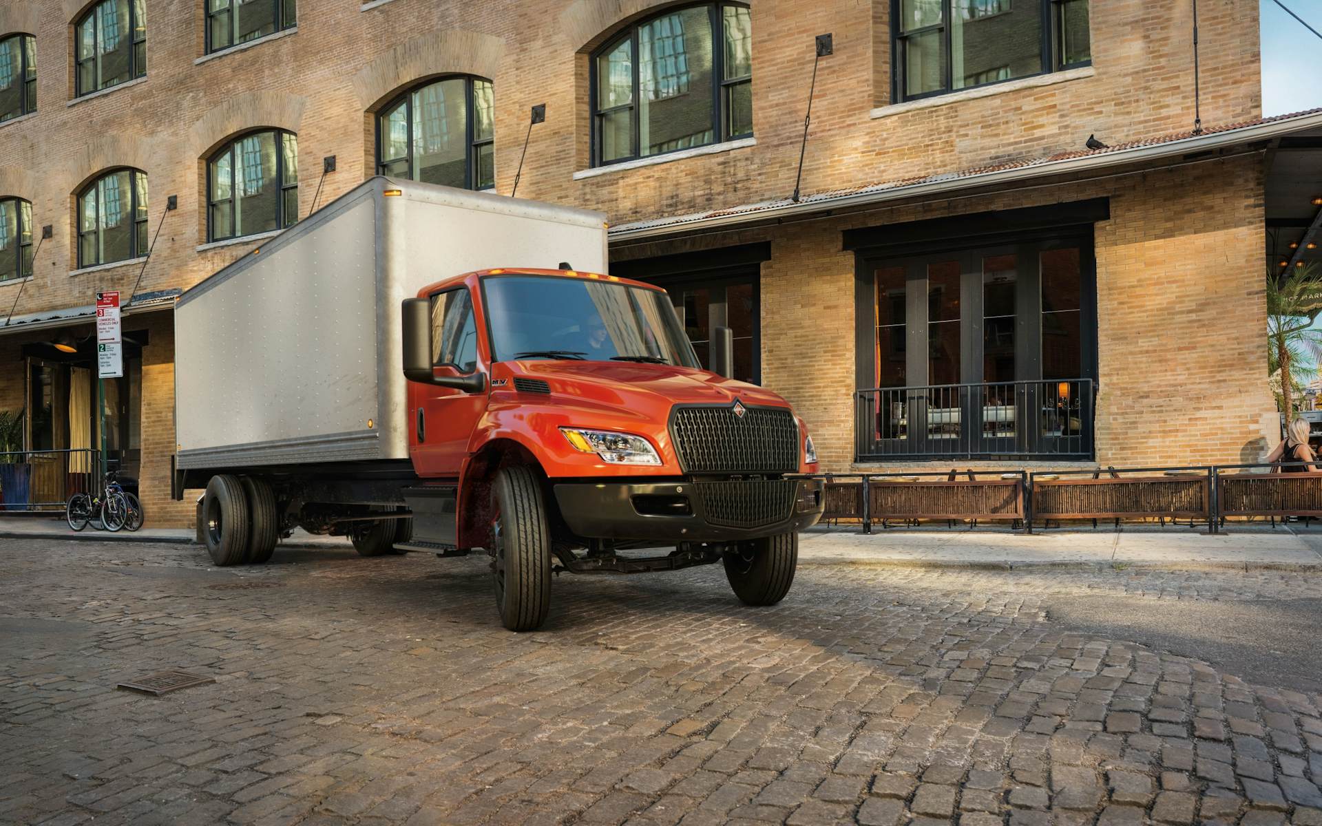 A red truck parked outside of a building with no people around