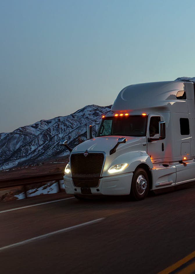 International LT in foreground at night on concrete road with snowy mountains