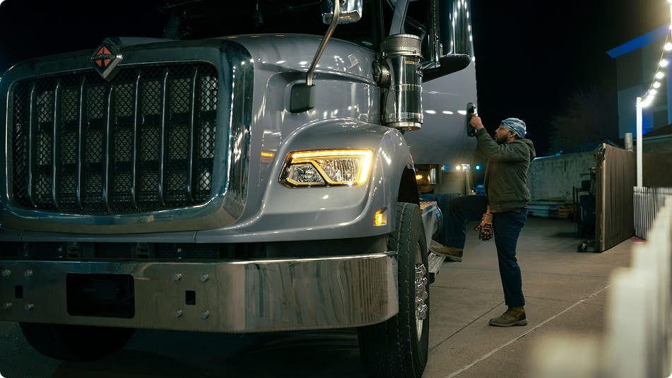 An employee standing next to a large truck
